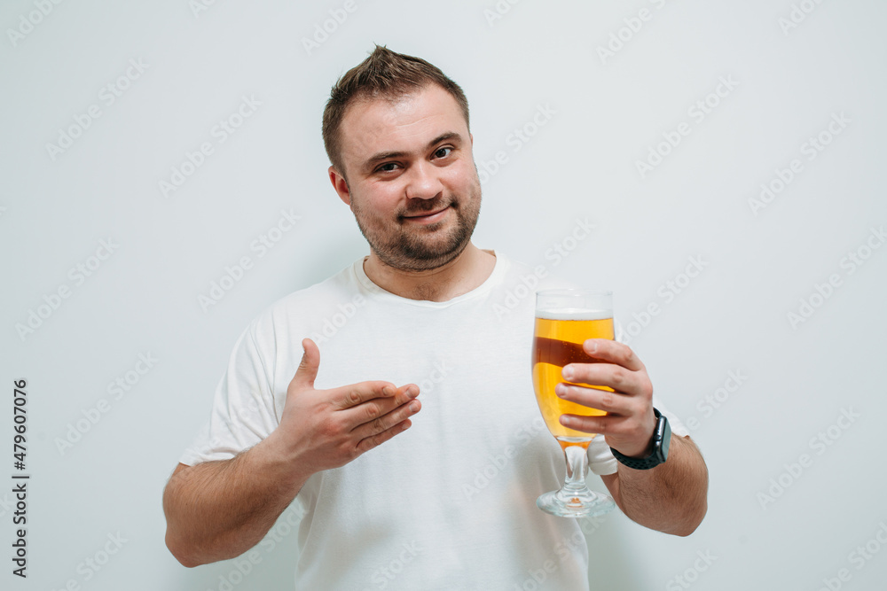 Positive bearded fat guy with a big glass of beer and smiling. Funny young man feeling happy and relaxed, with cold fresh beer in his hands after a hard day at work Positive bearded fat guy with a big glass of beer and smiling. Funny young man feeling happy and relaxed, with cold fresh beer in his hands after a hard day at work