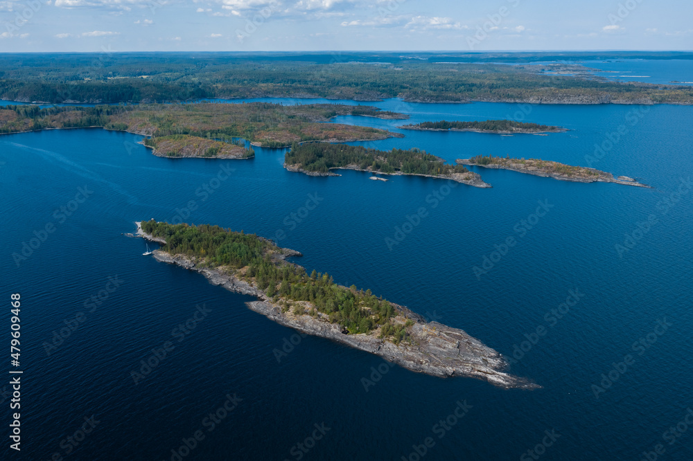 Aerial photography on Ladoga skerries. Ladoga Lake in Karelia in hot summer. Rocky wild islands in the middle of the lake. Russian nature