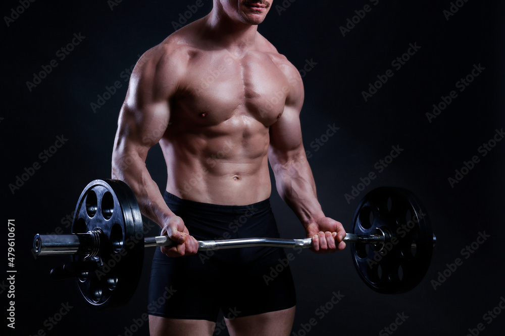 Professional bodybuilder performing biceps curls exercise with curved barbell over isolated black background. Studio shot of a fitness model with ez bar. Close up, copy space. Professional bodybuilder performing biceps curls exercise with curved barbell over isolated black background. Studio shot of a fitness model with ez bar. Close up, copy space.