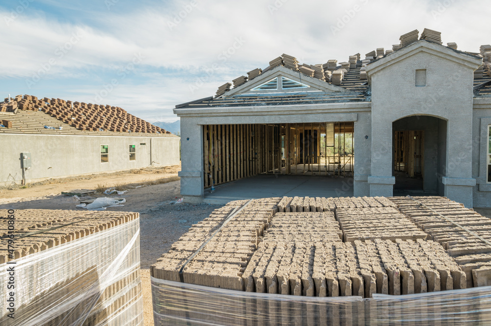 Obraz premium New home construction in with roof tiles in foreground