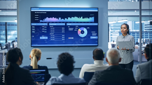 Presentation Event: Black Businesswoman Talks about e-Commerce Product Showing TV with Big Data Statistics, Charts, Revenue Growth Infographics. Press Conference for Digital Entrepreneurs.