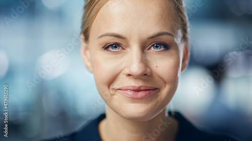 Portrait of Gorgeous Caucasian Woman with Deep Blue Eyes  Blonde Hair  Perfect Smile. Beautiful Girl Looks up at the Camera Happily. Abstract Bokeh out of Focus Background. Close-up Shot