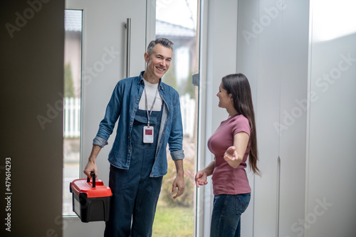 Fotografie Woman inviting man to the house with tools