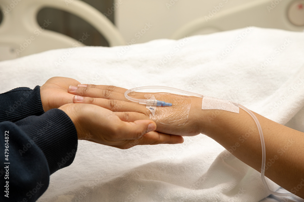 Elder senior hold woman patient hand sleeping on bed in hospital room. Health care medical concept Elder senior hold woman patient hand sleeping on bed in hospital room. Health care medical concept