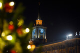 Clock tower through Christmas decorations. Yekaterinburg on New Year's Eve.