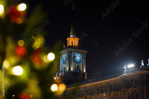 Clock tower through Christmas decorations. Yekaterinburg on New Year's Eve. photo