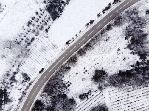 High angle top down aerial view drone image on road trough the trees and forest in mountain range covered with white snow in winter day near Knjazevac in Serbia - Travel journey and vacation concept photo