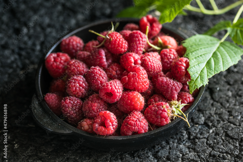 Raspberries in bowl on a dark wooden table, selective focus. Ingredients for raspberry juice or desserts. Raspberries on bowl. Raspberry with copy space for text. Various fresh summer berry . Raspberries in bowl on a dark wooden table, selective focus. Ingredients for raspberry juice or desserts. Raspberries on bowl. Raspberry with copy space for text. Various fresh summer berry .