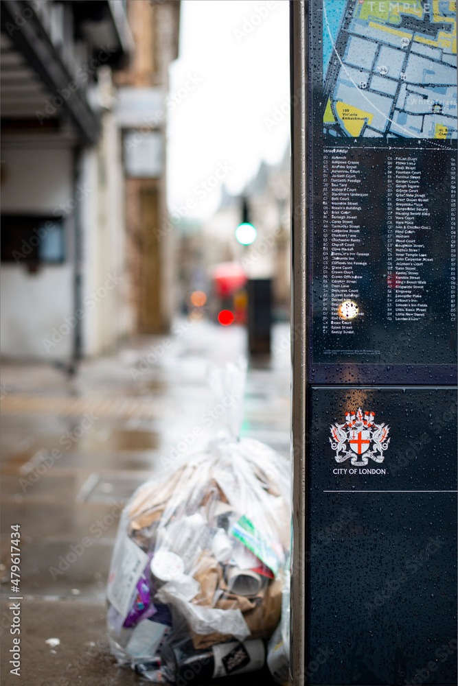 Obraz premium London, December 27th 2021: A bag of garbage next to a London street sign