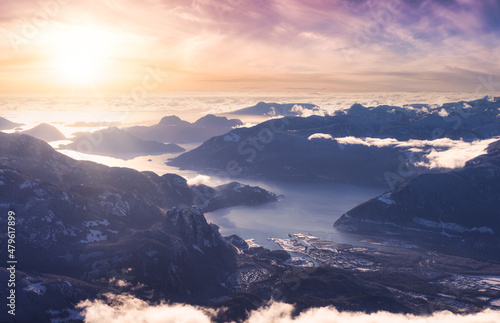 Aerial View of a small city, Squamish, in Howe Sound during winter season. Sunst Sky Art Render. Located north of Vancouver, British Columbia, Canada.