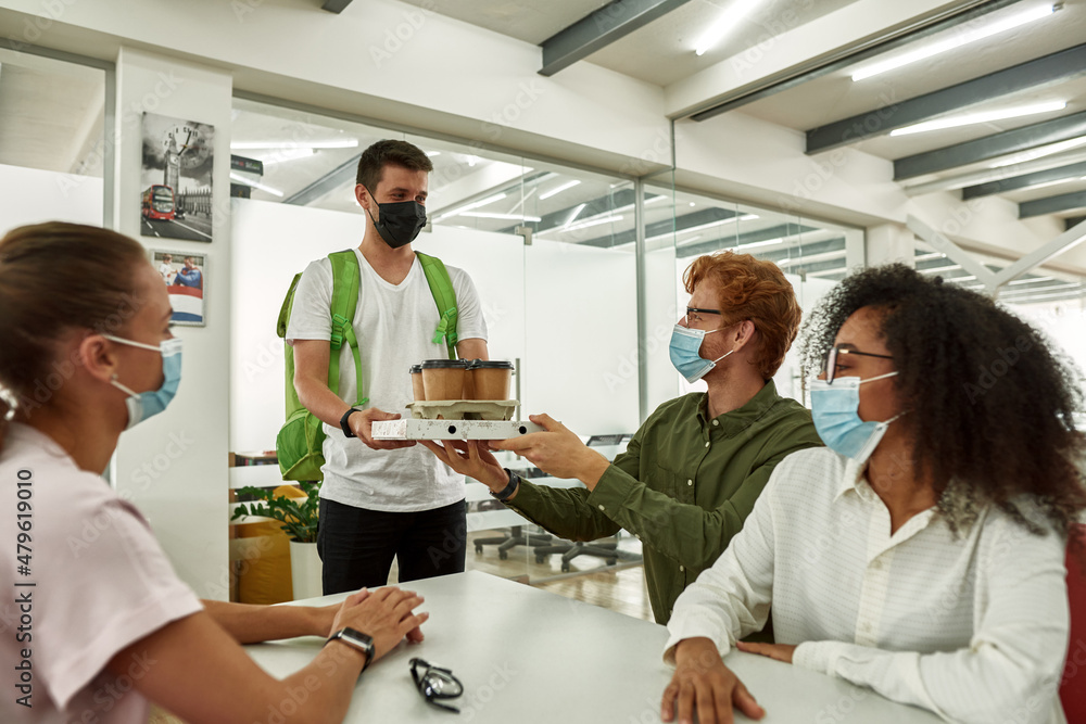 Obraz premium Courrier give pizza and coffee to office employees