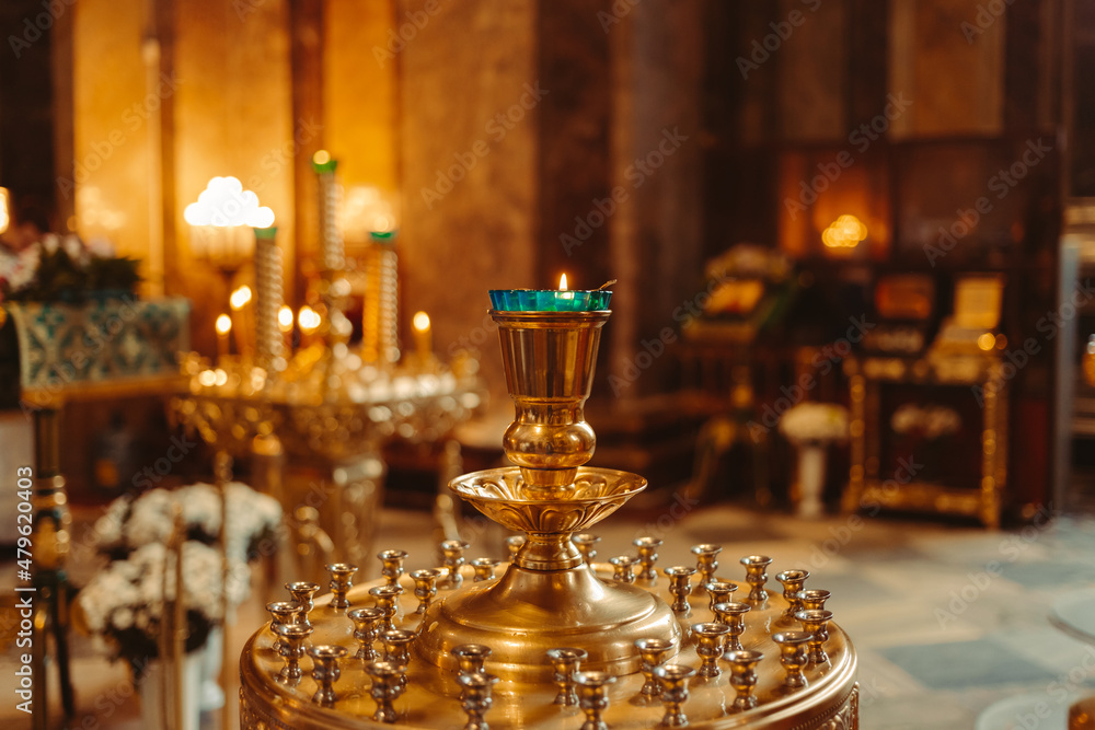 The lamp burns in the Christian Orthodox Cathedral. The room for the sacrament of baptism is lit by candles.