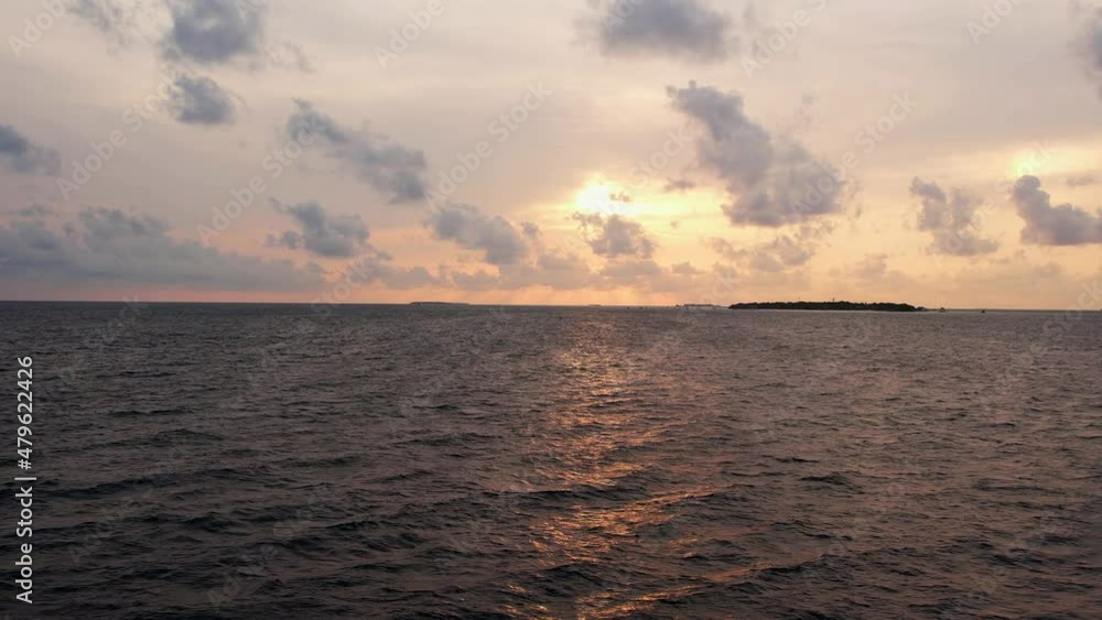 Drone shot of evening sea, picturesque sunset and island. Aerial shot of beautiful, panoramic skyline of ocean water and beach in Maldives at night. Concept of trip Drone shot of evening sea, picturesque sunset and island. Aerial shot of beautiful, panoramic skyline of ocean water and beach in Maldives at night. Concept of trip