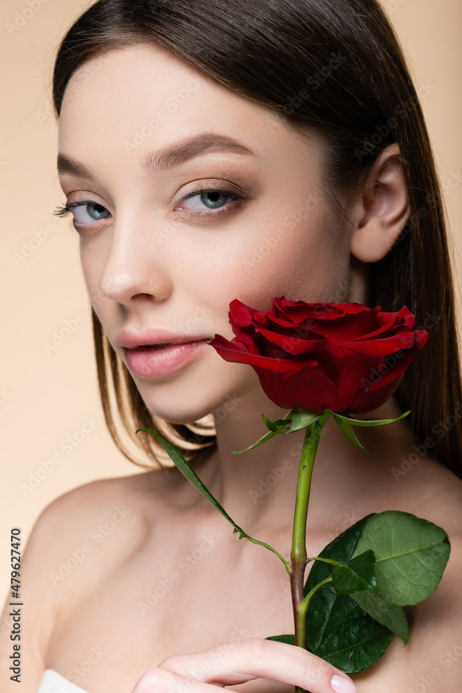 young woman with bare shoulders near rose isolated on beige young woman with bare shoulders near rose isolated on beige