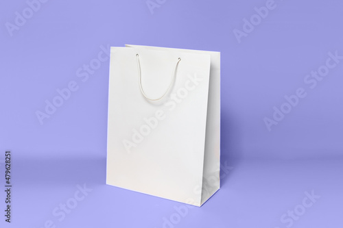 Mockup of white shopping bag isolated over lilac background. color of the year 2022 very peri. side view