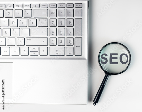 SEO, search engine optimization concept. Word through magnifying glass.