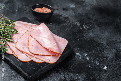 Squared slices of lean pork ham. Black background. Top view. Copy space