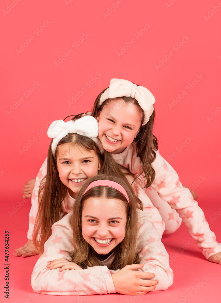 Pajama party is a real laugh. Happy sisters laughing lying close on each other. Laugh and be happy Pajama party is a real laugh. Happy sisters laughing lying close on each other. Laugh and be happy