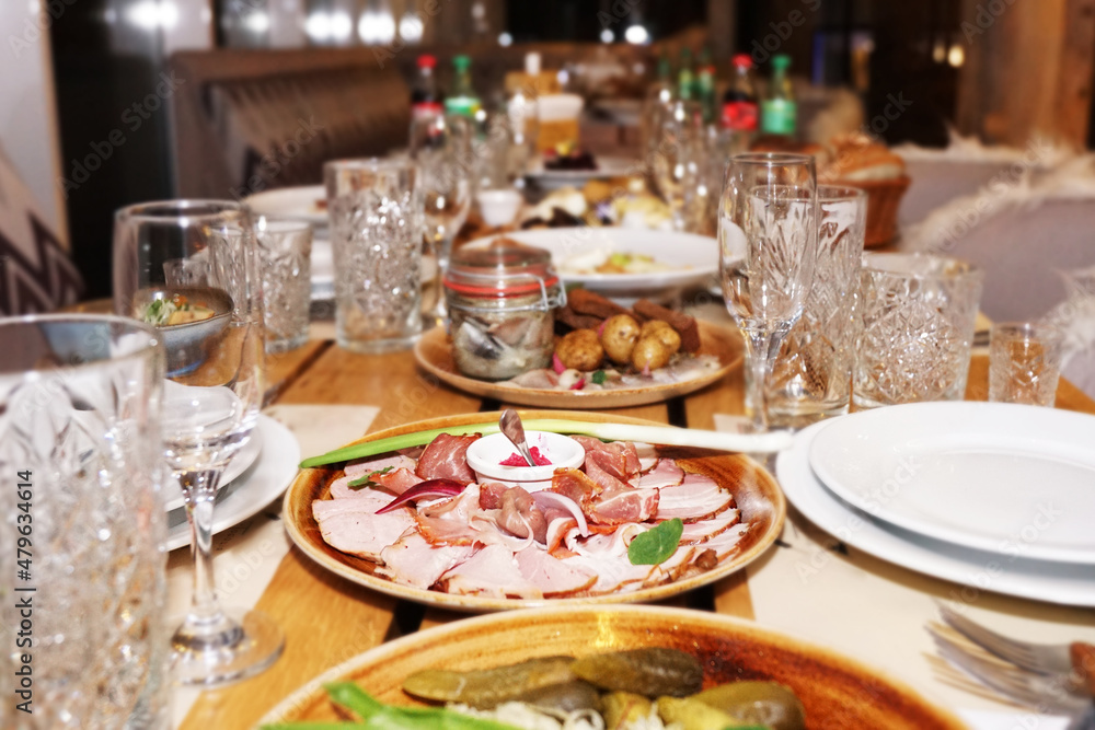 Traditional Ukrainian food - a plate with meat, baked potato on a wooden table. Festive served table