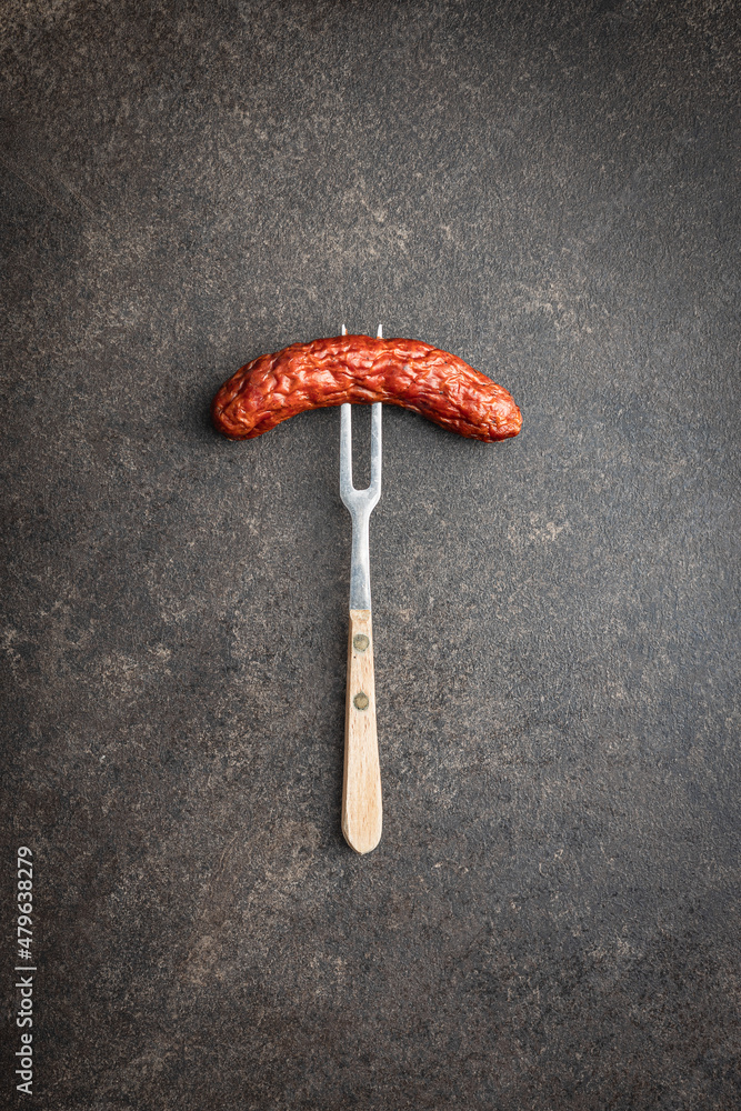 Smoked sausage pricked on a fork. Smoked sausage pricked on a fork.