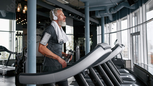 Tired man finished cardio exercises on treadmill