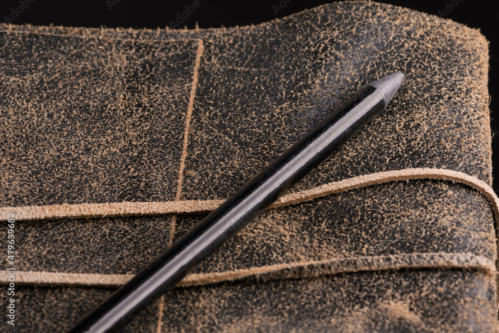 Black pencil on a leather-bound diary Black pencil on a leather-bound diary