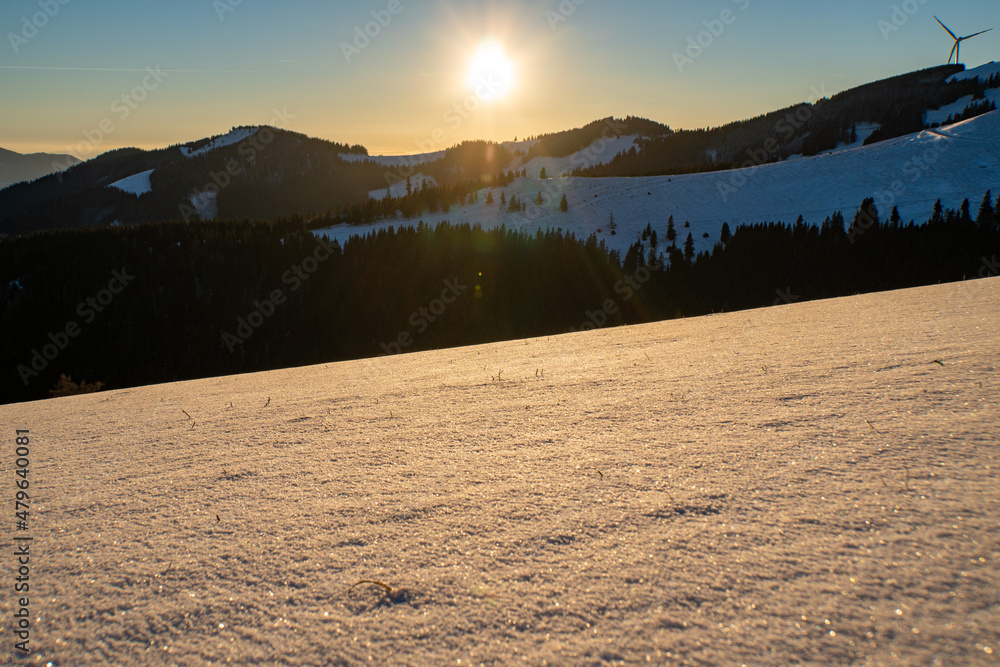 Ausblick auf das steirische Almenland im Winter während des Sonnenuntergangs