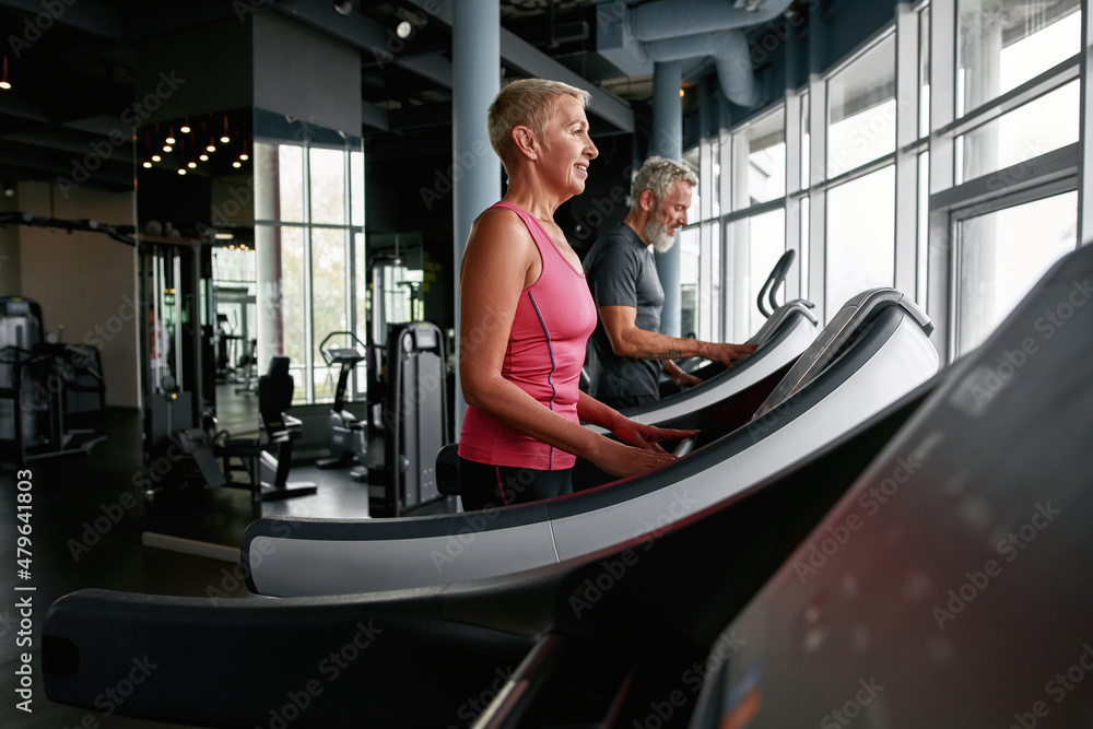 Side view of active seniors on stepping machine. Side view of active seniors on stepping machine.