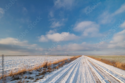 Pusta ośnieżona droga przez pola w zimie 