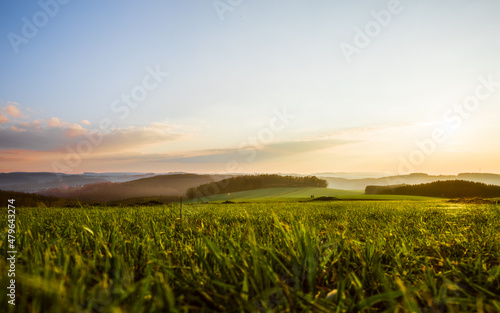 Landschaft bei Sonnenuntergang mit Dunst   ber den Feldern