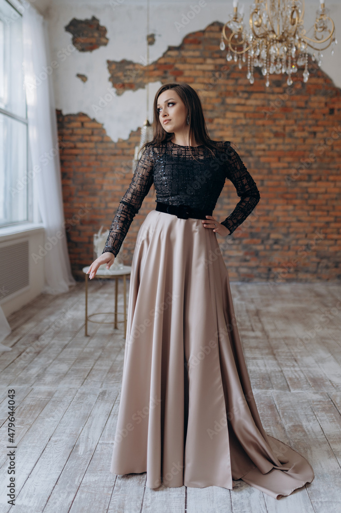 The girl is beautiful in a dark beige dress smile shows the dress The girl is beautiful in a dark beige dress smile shows the dress