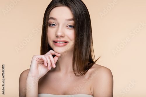 cheerful young woman with bare shoulders isolated on beige