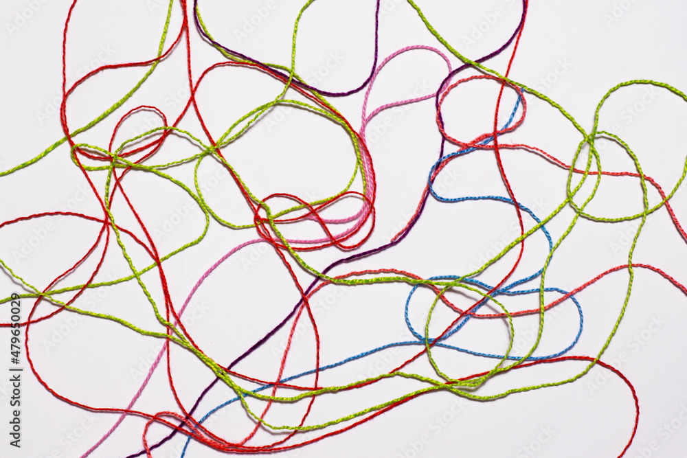 Red, green, pink, blue threads are scattered on a gray background. Yarn for creativity. Red, green, pink, blue threads are scattered on a gray background. Yarn for creativity.