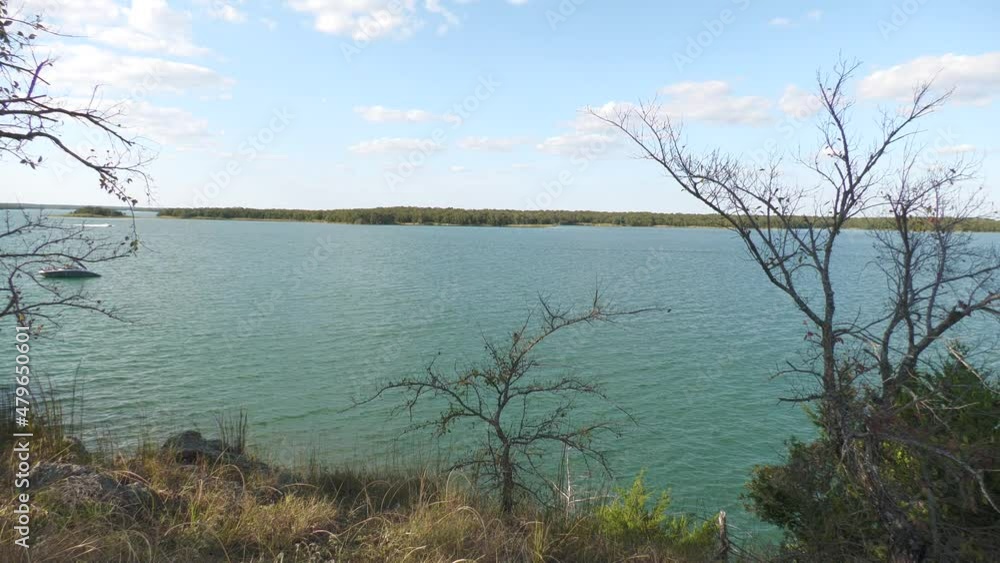 Steady shot of a lake with a speedboat in the distance Steady shot of a lake with a speedboat in the distance