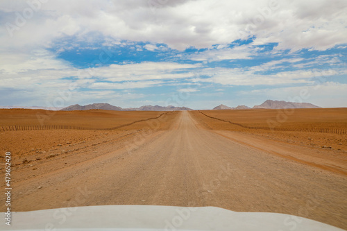 Endless and lonely road through the desert going into the mountains of Namibia