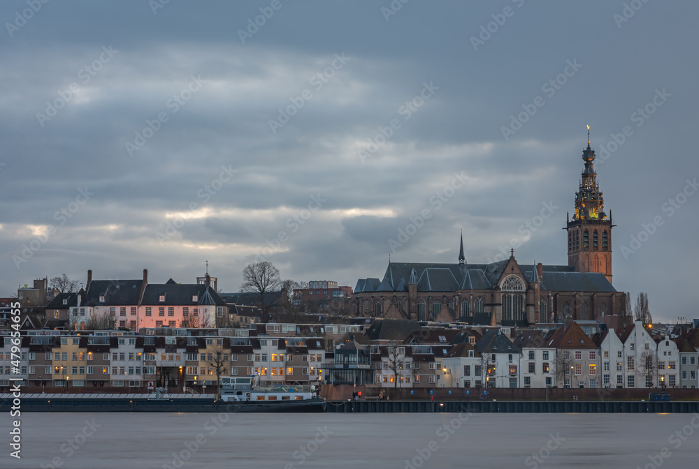 Skyline of dutch city Nijmegen at dusk with majestic Stephen's Church along the Waal river