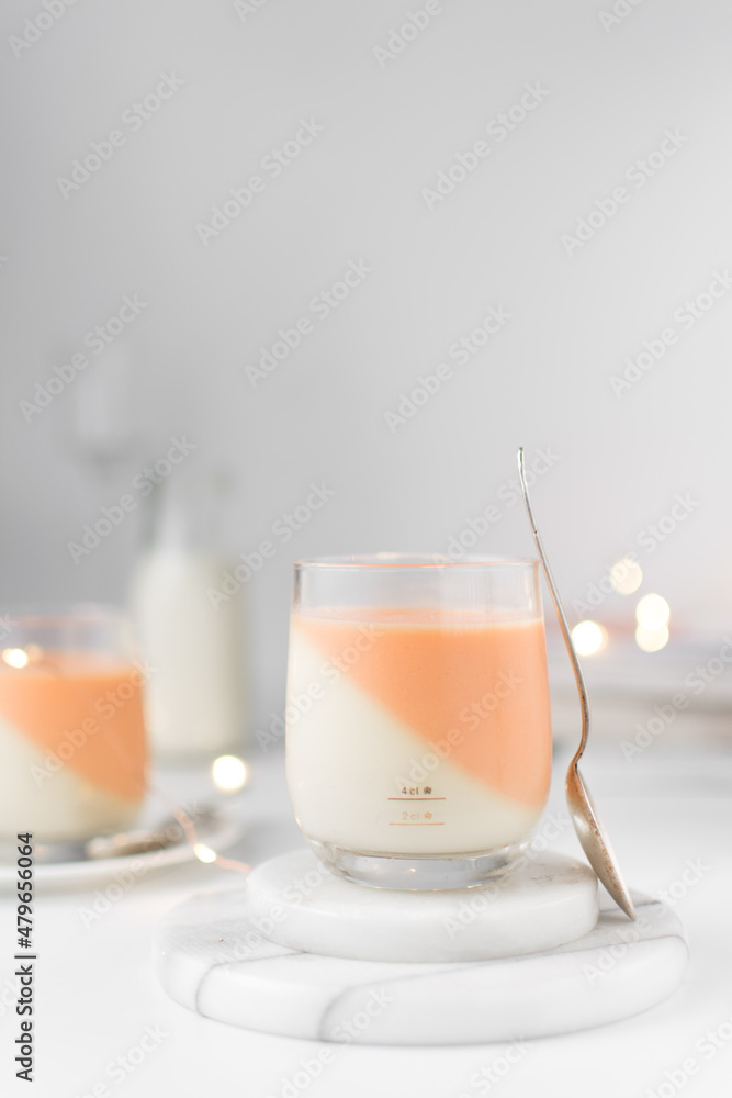 Vanilla and orange creamsicle panna cotta, panna cotta served in a glass cup, cooked cream in a glass cup, coral panna cotta dessert Vanilla and orange creamsicle panna cotta, panna cotta served in a glass cup, cooked cream in a glass cup, coral panna cotta dessert