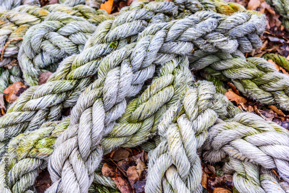 A close up of dirty old grey braided rope found on a dock.