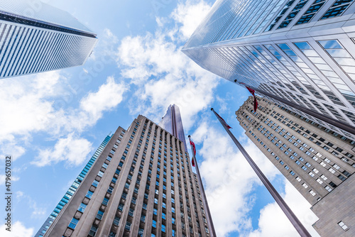 Looking up at the skyscrapers in the downtown financial district of Toronto Canada as they reach the for the cloudy blue sky.