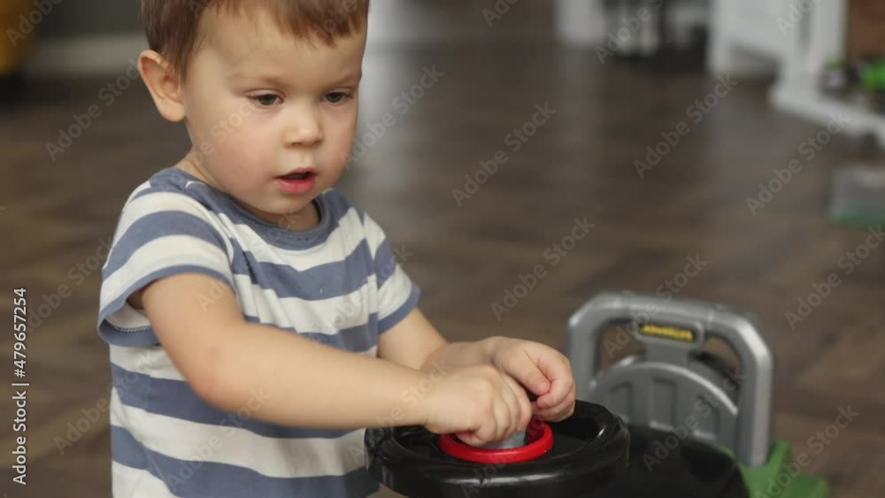 little caucasian baby boy playing toy car pretending being mechanic engineer fixing and repairing vehicle using instrument tools. serious face expression child kid focused on work at home living room little caucasian baby boy playing toy car pretending being mechanic engineer fixing and repairing vehicle using instrument tools. serious face expression child kid focused on work at home living room