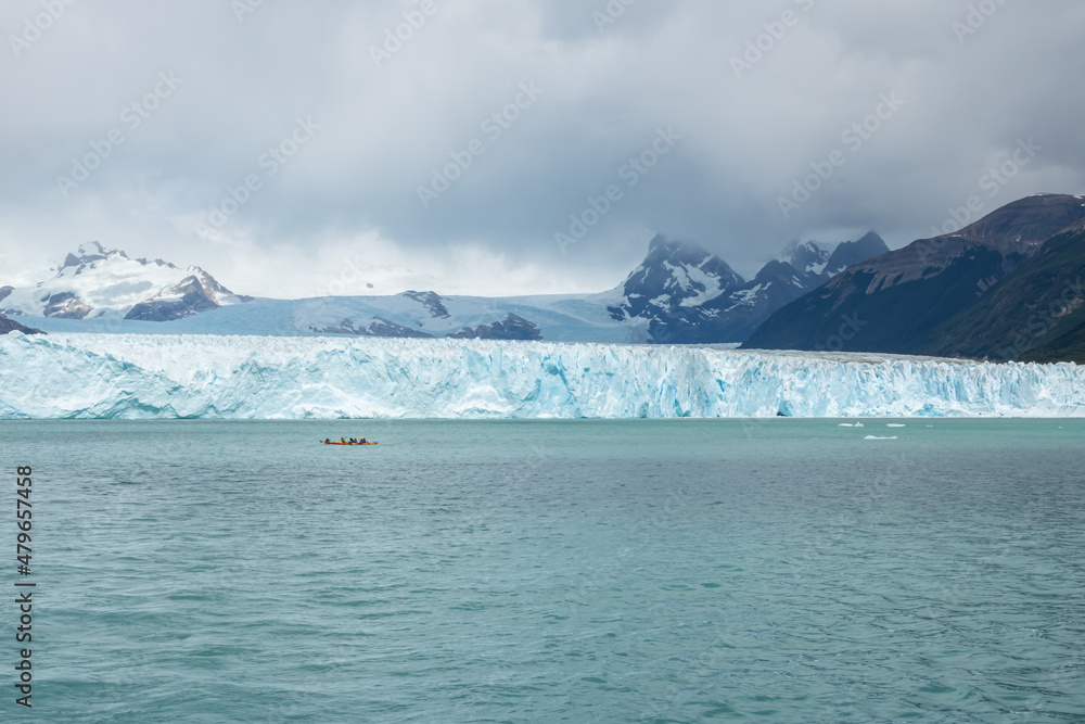 Glacier landscape with mountains and distant kayak Glacier landscape with mountains and distant kayak