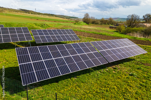 Aerial view of blue photovoltaic solar panels mounted on backyard ground for producing clean ecological electricity. Production of renewable energy concept.