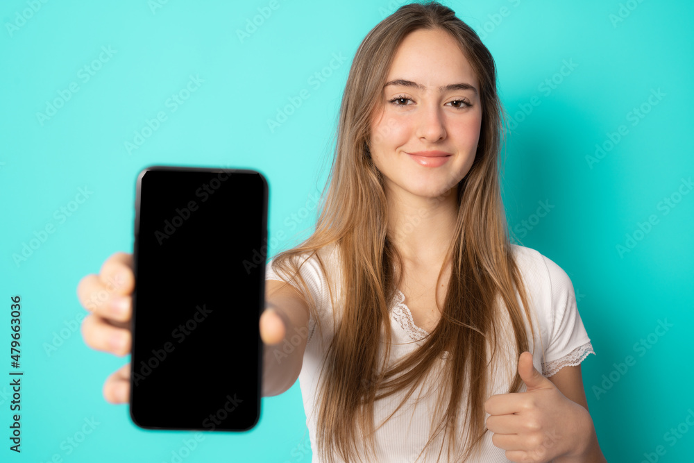 Close up portrait of young woman showing mobile screen over green background. Close up portrait of young woman showing mobile screen over green background.