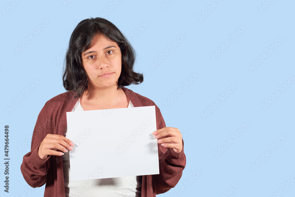 Serious latin young woman showing blank advertisement. Isolated Serious latin young woman showing blank advertisement. Isolated