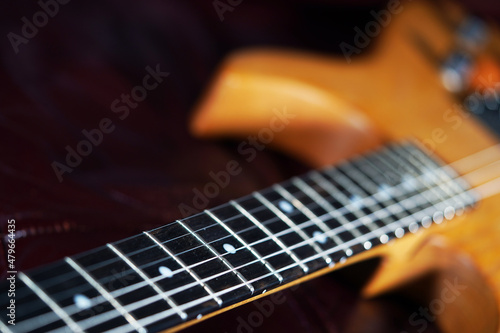 Art. Classical guitar close-up. Abstract background of musical stringed instruments. Wooden fretboard of a guitar. Sound wave. Metal strings straight lines. photo