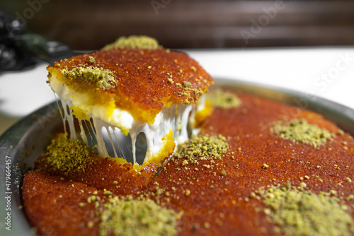Arabic traditional dessert - kunafa - konafa in a tray with pistachio - creative delicious middle eastern dish - Arabic Cuisine