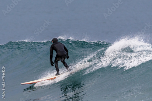 Extreme sport. Surfer rides on ice waves on a board. Winter surfing in Russia.