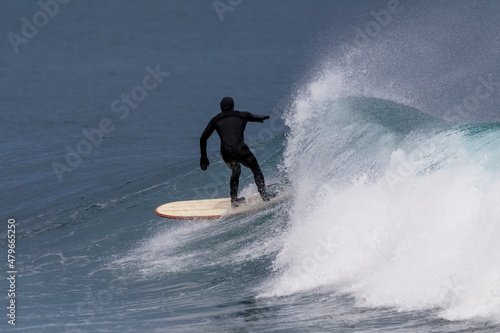 Extreme sport. Surfer rides on ice waves on a board. Winter surfing in Russia.