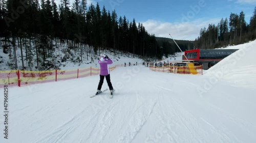 Skiers going downhill in a ski resort, active rest in winter mountains, extreme shooting in motion
