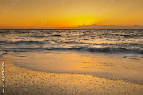 Paisaje de una puesta de sol en una orilla de una playa 